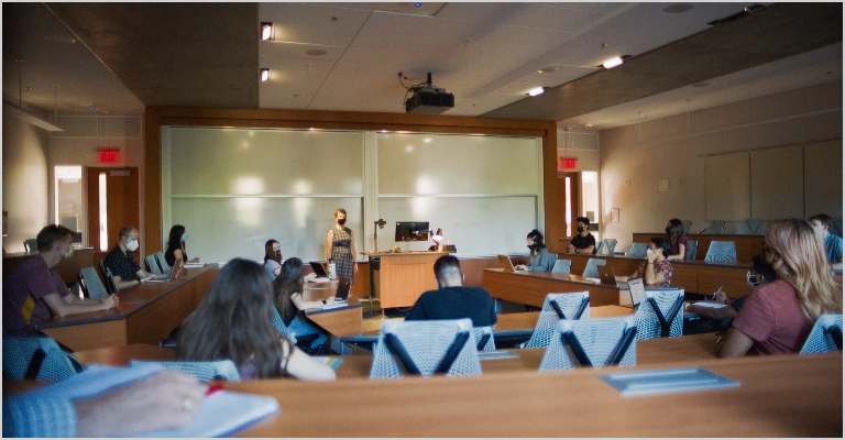 Back view of students in a lecture with instructor at the front