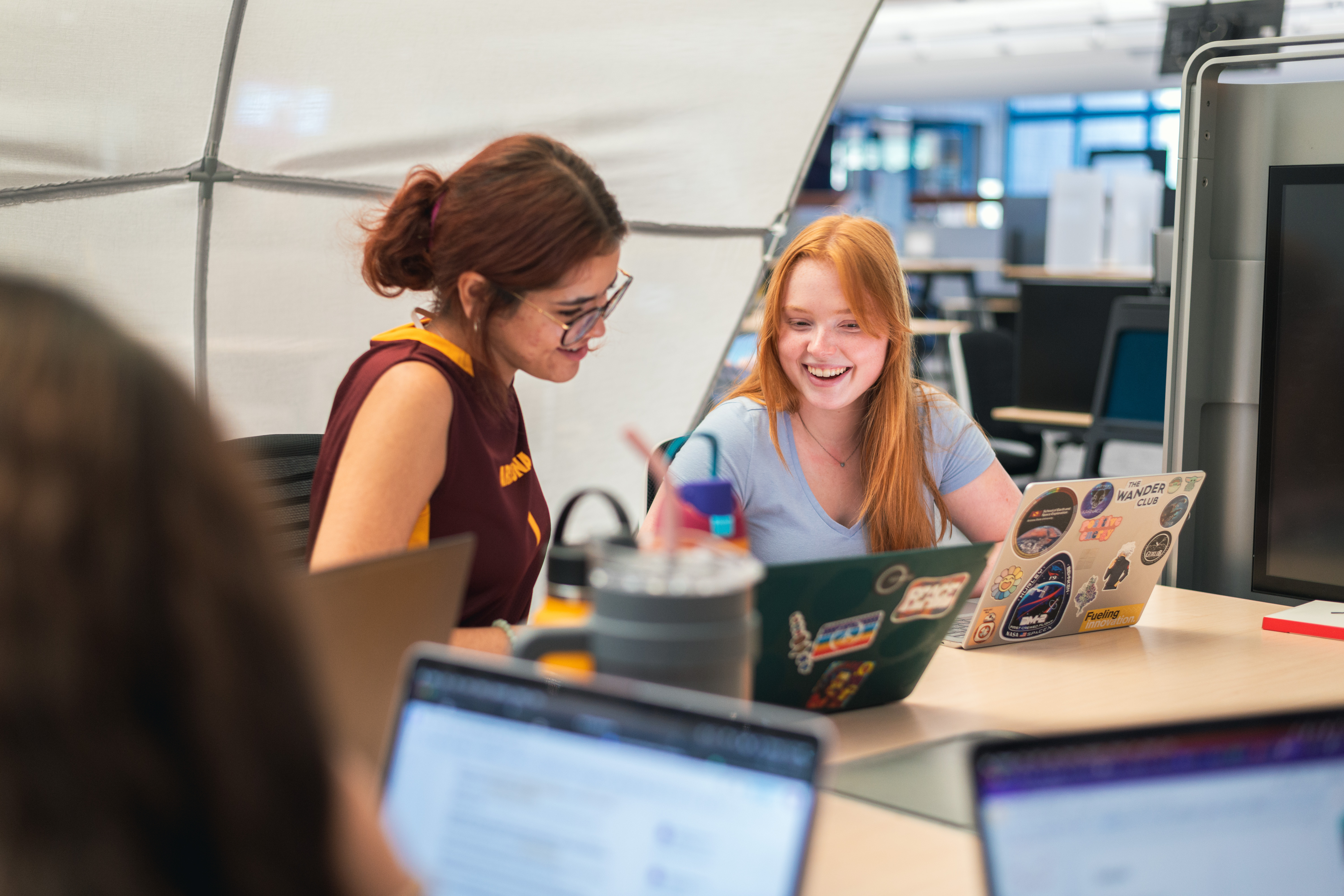 Two students looking at a laptop with contemplative faces